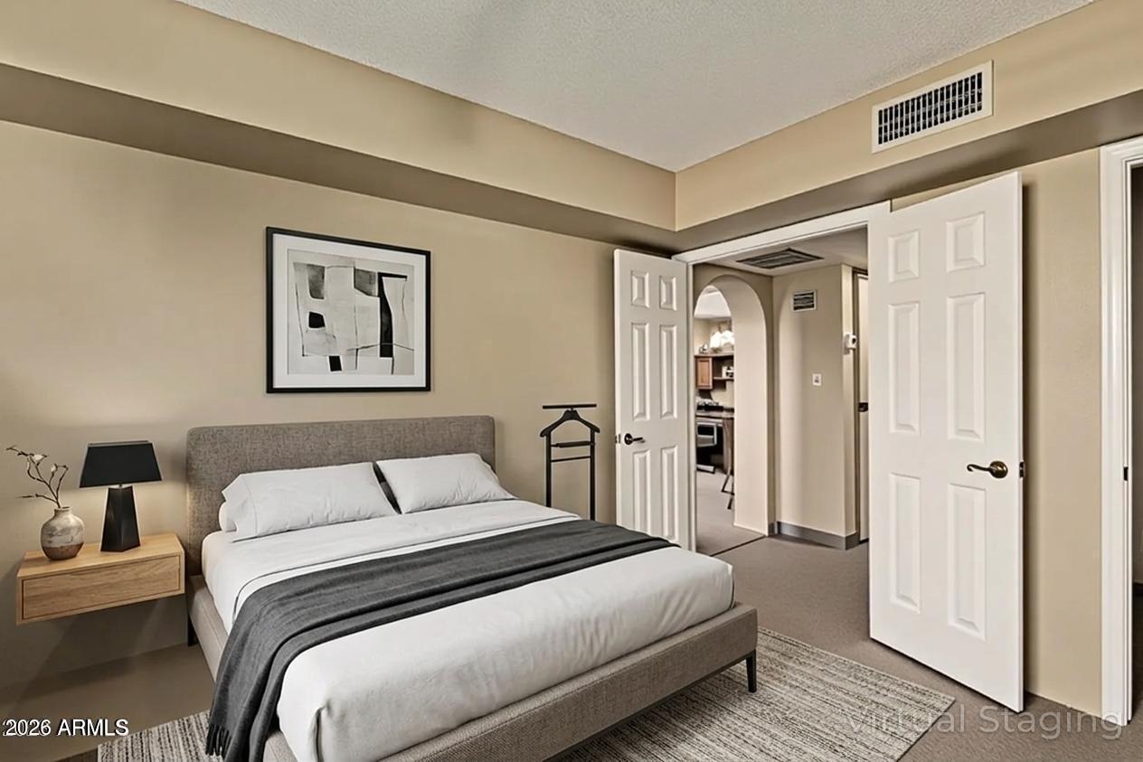 10410 North Cave Creek Road, Unit 1230 Phoenix, AZ 85020 - Photo 5 of 13 a bedroom with a large bed and a painting on the wall