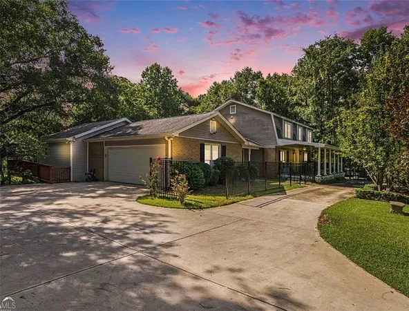a view of a house with backyard and trees
