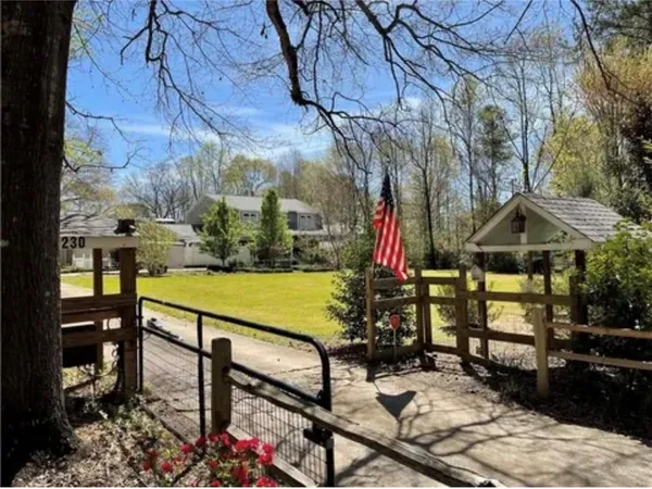 a view of swimming pool with seating area and trees in the background