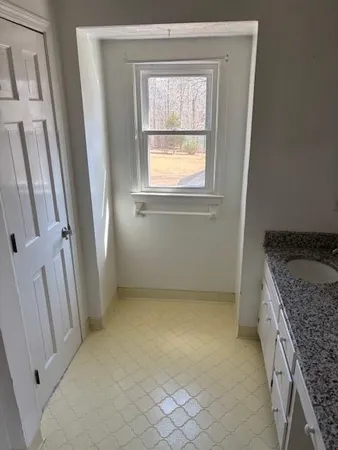 a view of empty room with window and wooden floor