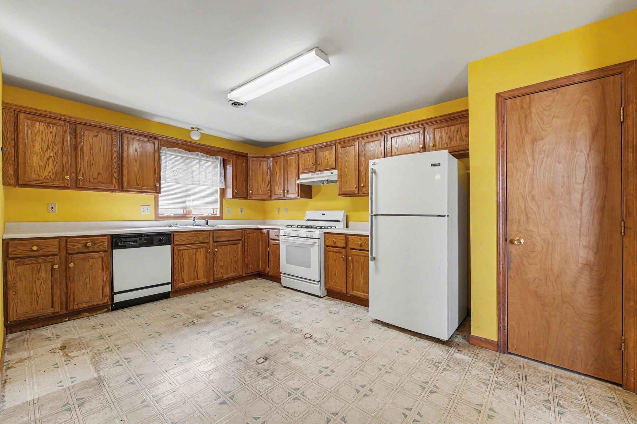 950 Blue Jay Way Dyer, IN 46311 - Photo 6 of 21 a kitchen with a refrigerator a sink and dishwasher with a large window