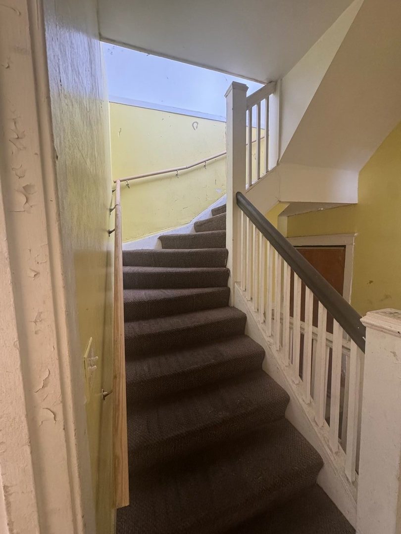 7007 South Ada Street Chicago, IL 60636 - Photo 13 of 49 a view of staircase with wooden floor and white walls