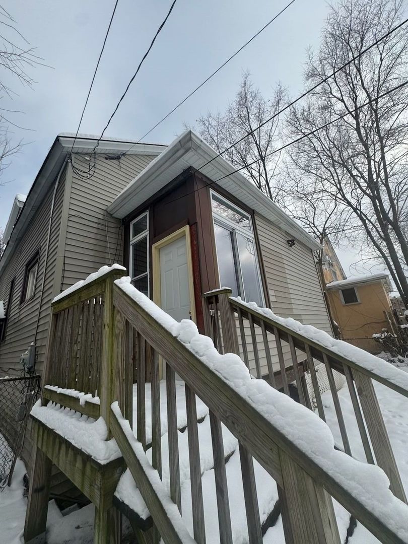 7007 South Ada Street Chicago, IL 60636 - Photo 2 of 49 a view of wooden house with large trees and wooden fence
