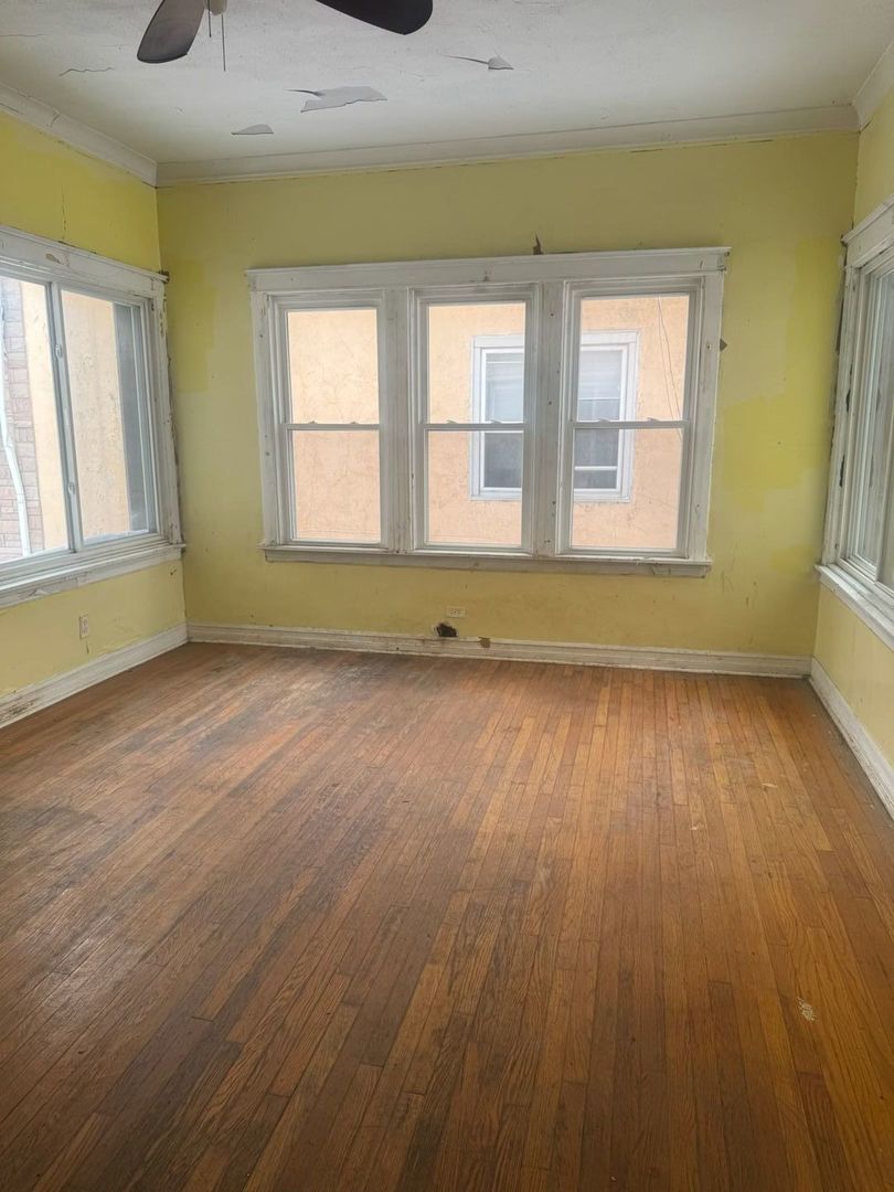 7007 South Ada Street Chicago, IL 60636 - Photo 3 of 49 a view of an empty room with wooden floor and a window