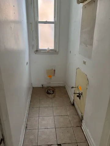 a view of an empty room with wooden floor and window
