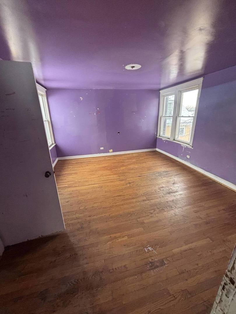 7007 South Ada Street Chicago, IL 60636 - Photo 5 of 49 a view of an empty room with window and wooden floor