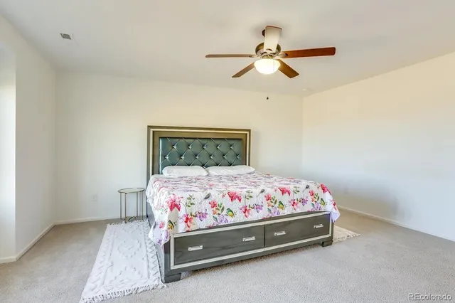 a bedroom with a bed and a chandelier fan