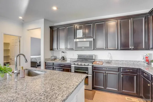 a kitchen with stainless steel appliances granite countertop a stove sink and cabinets