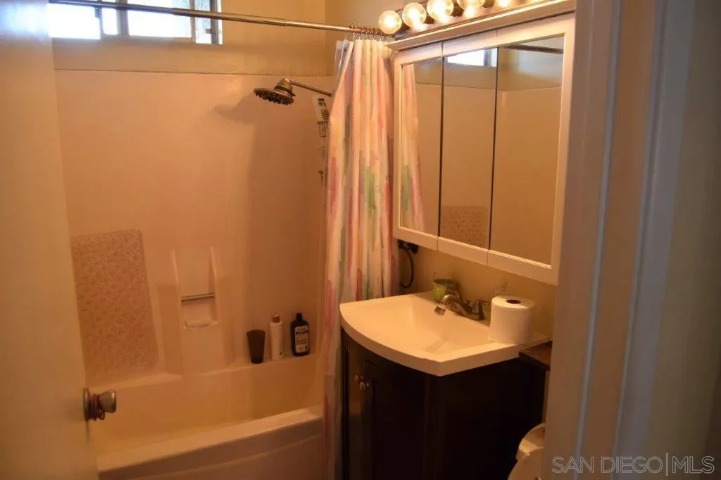 3159-3161 Cedar Street San Diego, CA 92102 - Photo 26 of 39 a bathroom with a sink and mirror with bathtub