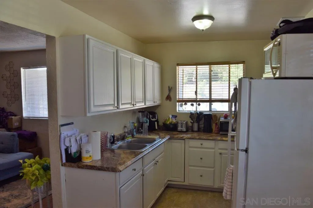3159-3161 Cedar Street San Diego, CA 92102 - Photo 29 of 39 a kitchen with granite countertop a sink stove and cabinets