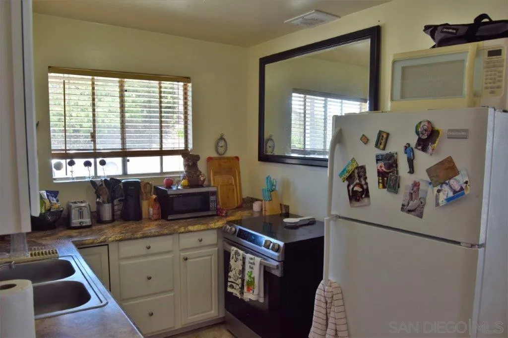 3159-3161 Cedar Street San Diego, CA 92102 - Photo 30 of 39 a kitchen with a refrigerator and window