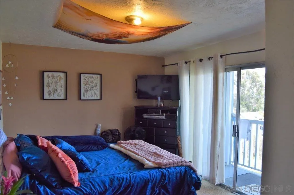 3159-3161 Cedar Street San Diego, CA 92102 - Photo 32 of 39 a bedroom with a bed and a chandelier