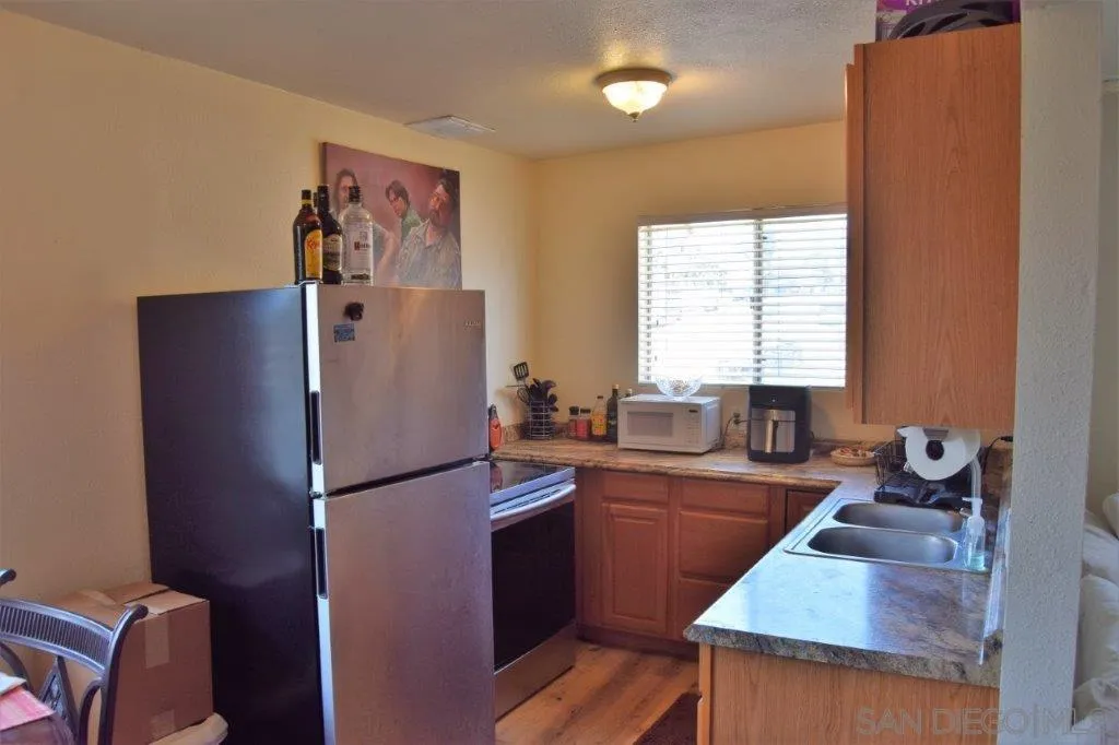 3159-3161 Cedar Street San Diego, CA 92102 - Photo 6 of 39 a kitchen with stainless steel appliances granite countertop a refrigerator a sink a stove and a refrigerator