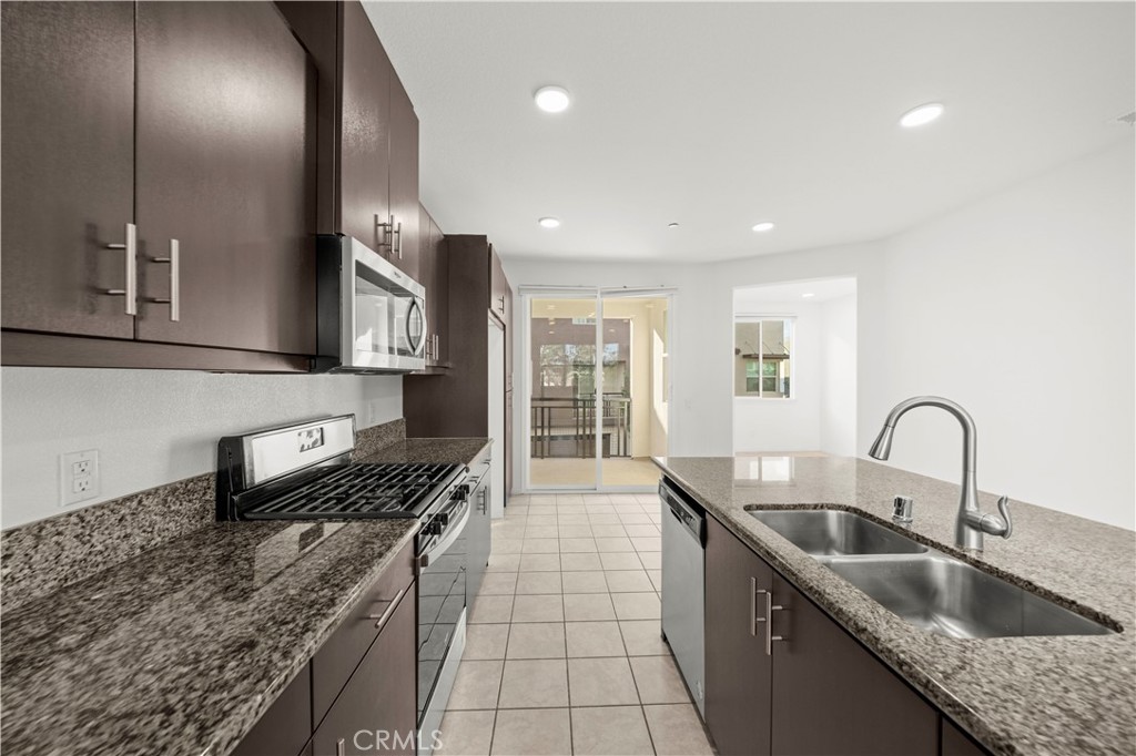 7803 Paxton Place Rancho Cucamonga, CA 91730 - Photo 19 of 44 a kitchen with stainless steel appliances granite countertop a sink a stove and a wooden floors