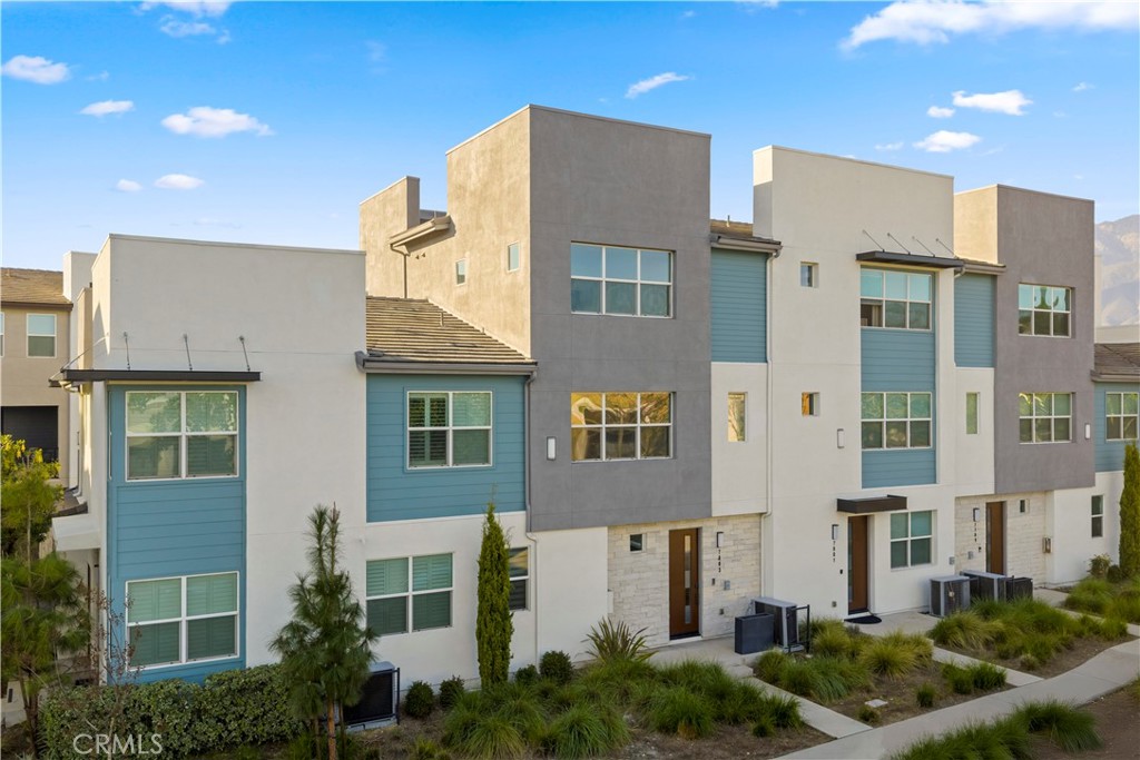 7803 Paxton Place Rancho Cucamonga, CA 91730 - Photo 2 of 44 a front view of a residential apartment building with a yard