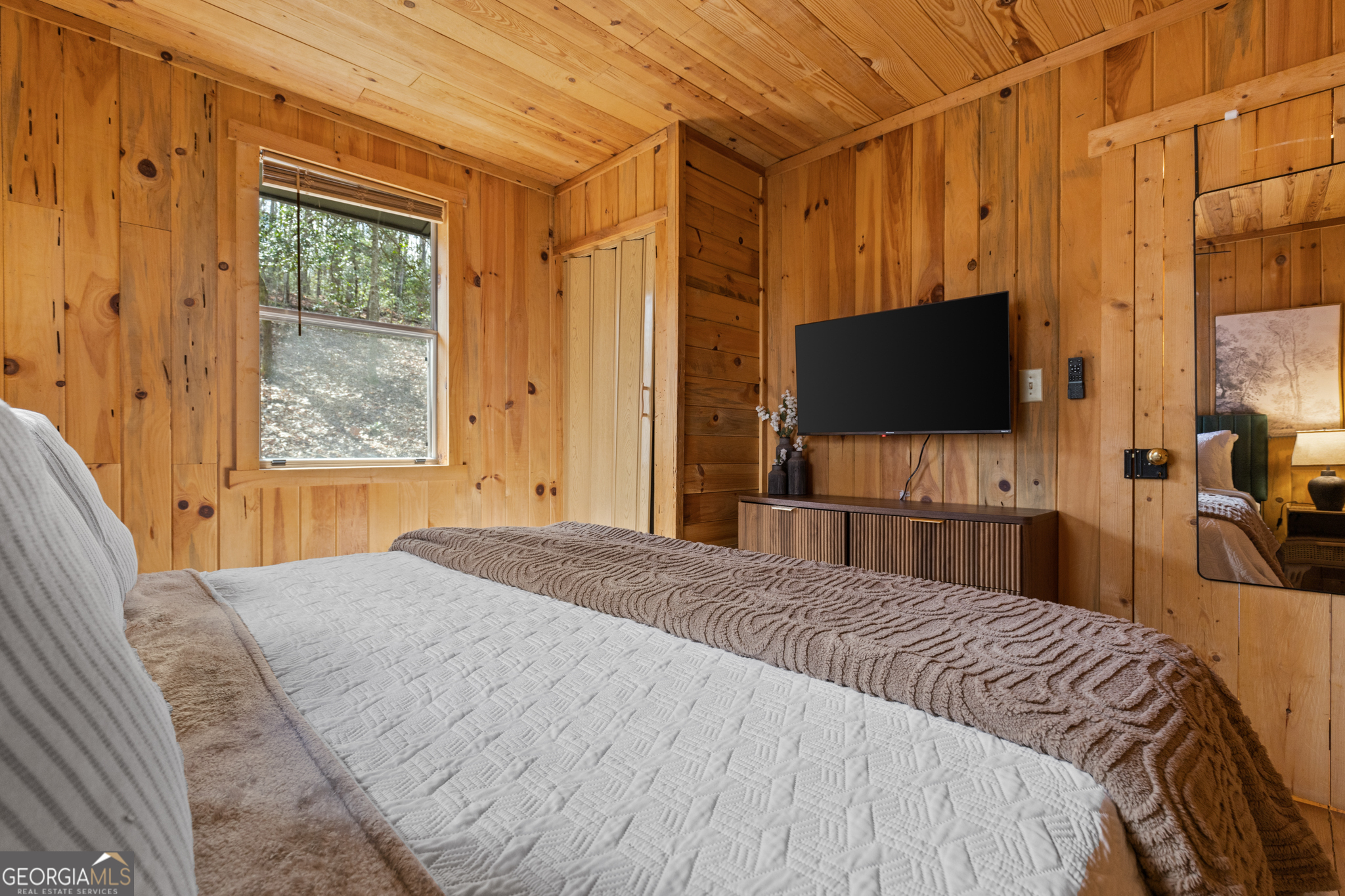 222 Icy Lane Blue Ridge, GA 30513 - Photo 29 of 37 a bedroom with a bed and a flat tv screen on dresser