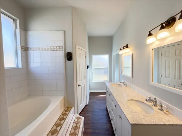 a spacious bathroom with a granite countertop tub sink and mirror