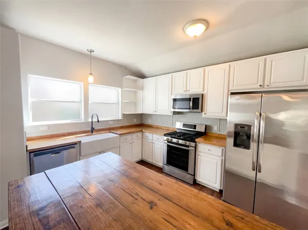 a kitchen with granite countertop a refrigerator stove top oven and sink
