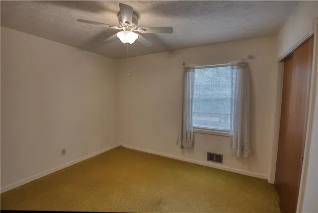 a view of a big room with closet fan and windows