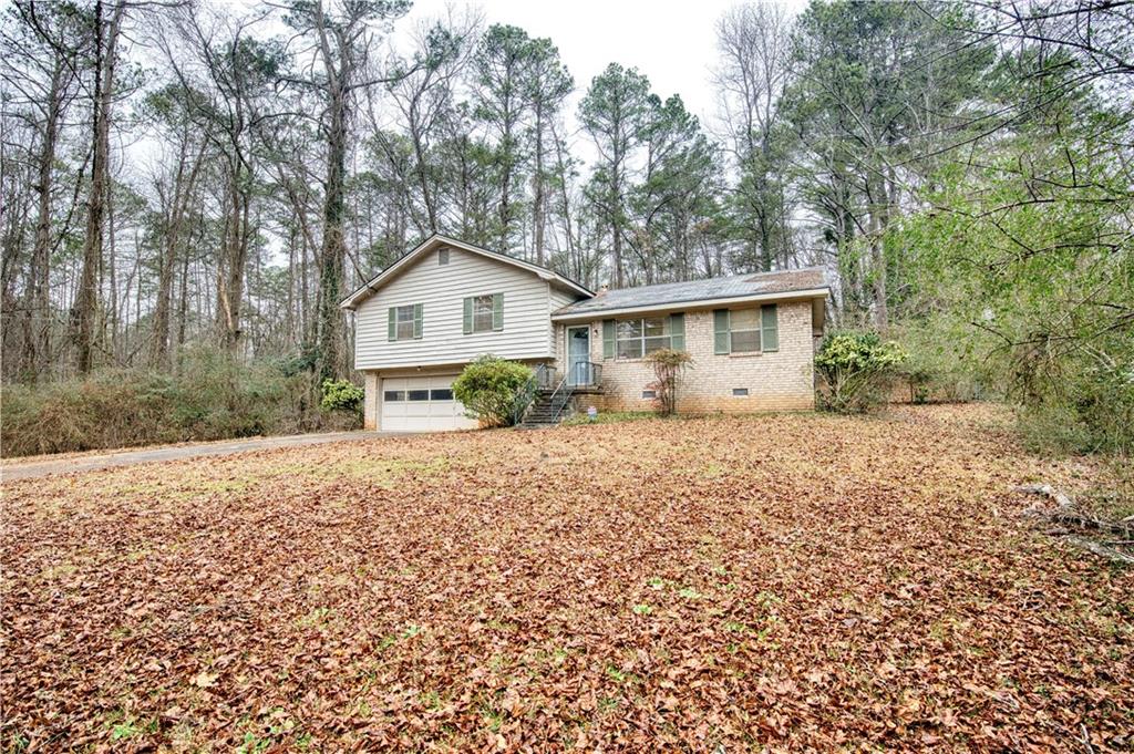 6100 Mincey Road Stone Mountain, GA 30087 - Photo 2 of 40 a view of a house with a yard and large trees