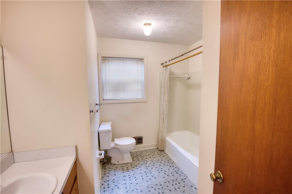 6100 Mincey Road Stone Mountain, GA 30087 - Photo 26 of 40 a bathroom with a toilet a sink and bathtub