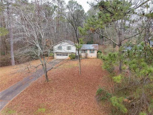 a backyard of a house with a yard and outdoor seating