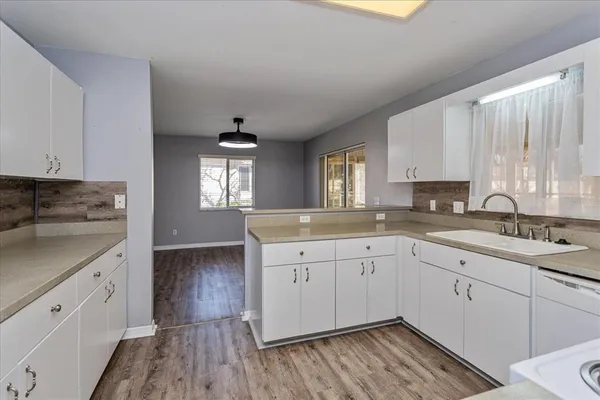 a kitchen with sink cabinets and wooden floor