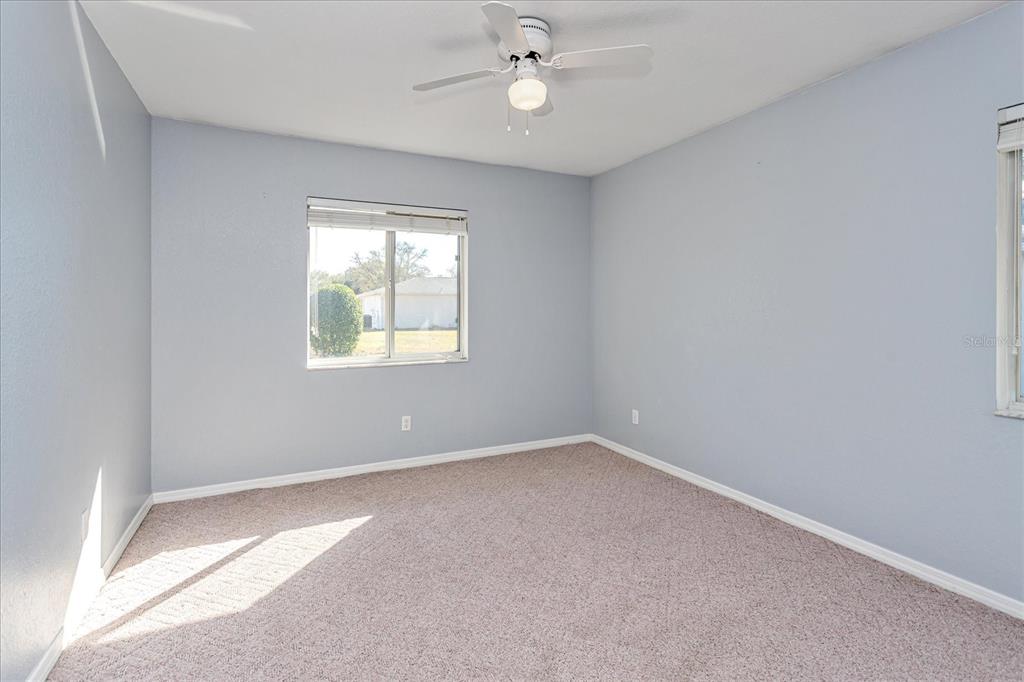 6114 Southwest 104th Street Ocala, FL 34476 - Photo 19 of 28 an empty room with windows and ceiling fan