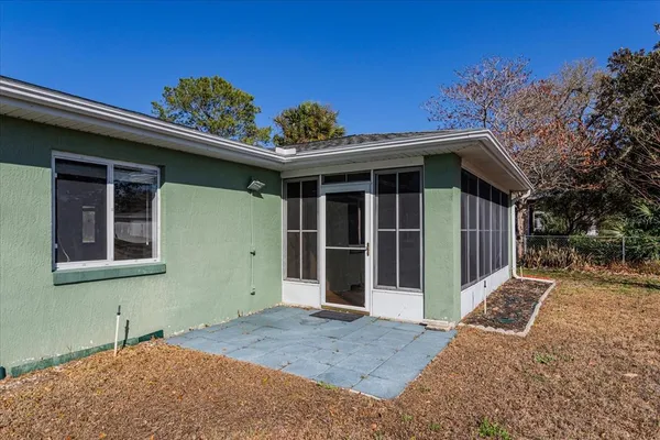 a view of a house with a large window and potted plants