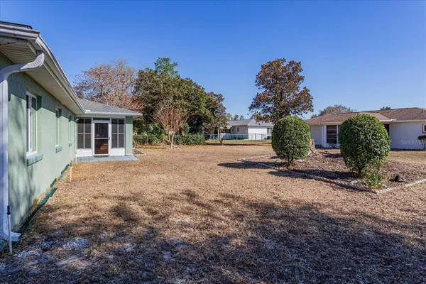 a view of a house with backyard and trees