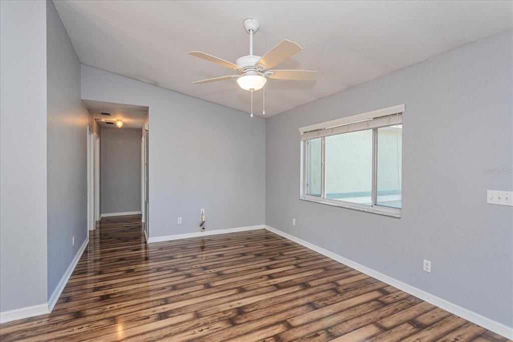 6114 Southwest 104th Street Ocala, FL 34476 - Photo 7 of 28 a view of an empty room with wooden floor and a window