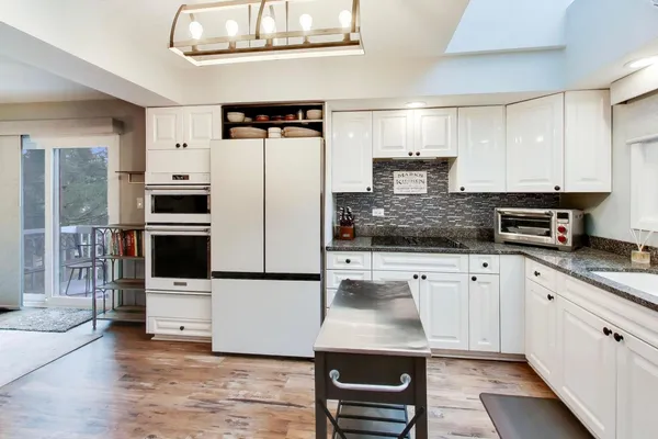 a kitchen with stainless steel appliances kitchen island granite countertop a stove a sink and a refrigerator