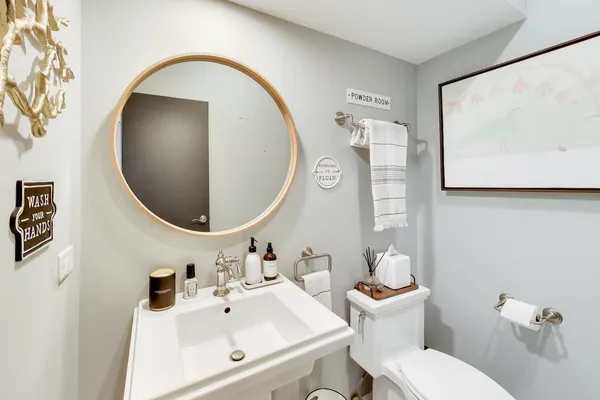 a bathroom with a toilet a sink and mirror