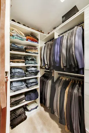 a view of walk in closet with clothes and shoes