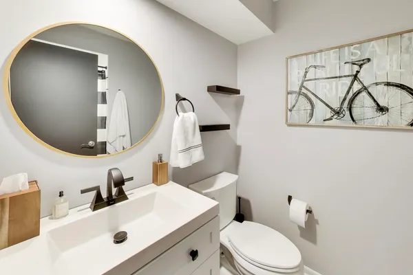 a bathroom with a sink a toilet and mirror