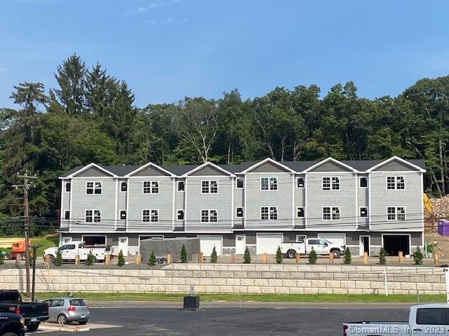 a front view of a house with a yard and parking space
