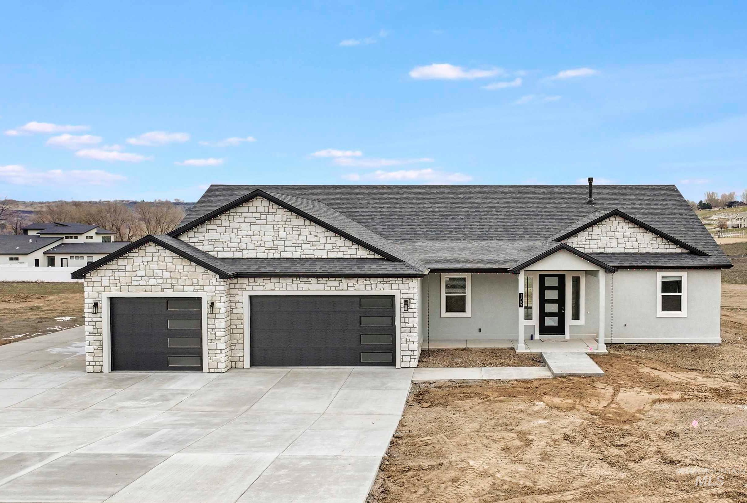 View of front of house with a shingled roof, concrete driveway, stone siding, a garage, and covered porch