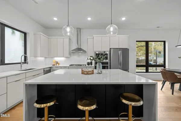 a kitchen with a dining table chairs stainless steel appliances and cabinets