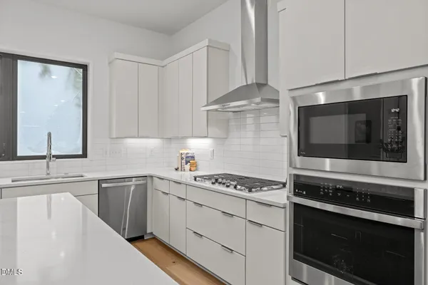 a kitchen with stainless steel appliances a stove microwave and cabinets