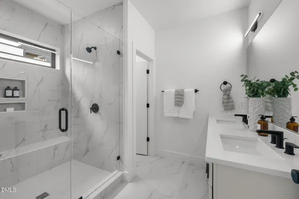 a bathroom with a sink a mirror and shower