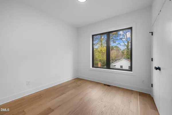 a view of a room with wooden floor and painting on the wall