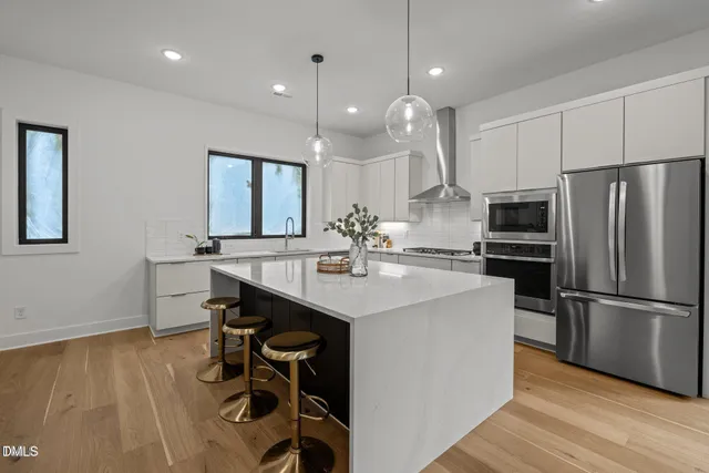 a kitchen with kitchen island a sink appliances and a counter top space