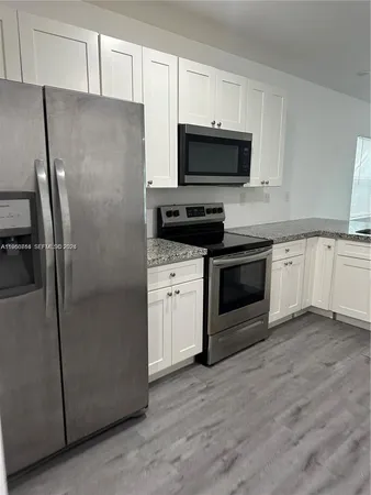 a kitchen with cabinets stainless steel appliances and a sink