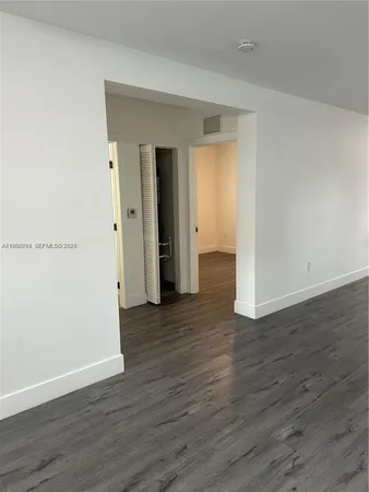 a view of a room with wooden floor