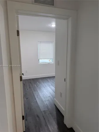 an empty room with wooden floor and closet