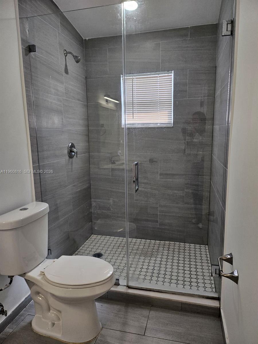 224 Northwest 57th Street, Unit B Miami, FL 33127 - Photo 39 of 40 a bathroom with a toilet and shower