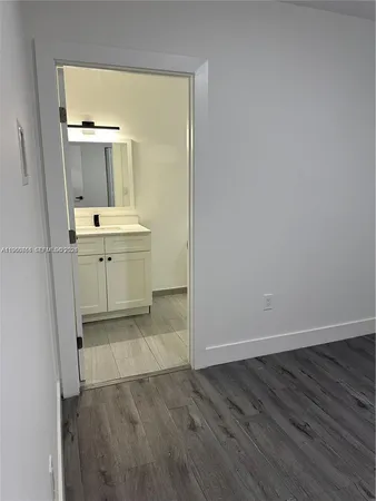 an empty room with a sink and a mirror