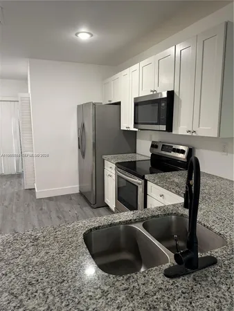a kitchen with a sink stove and refrigerator