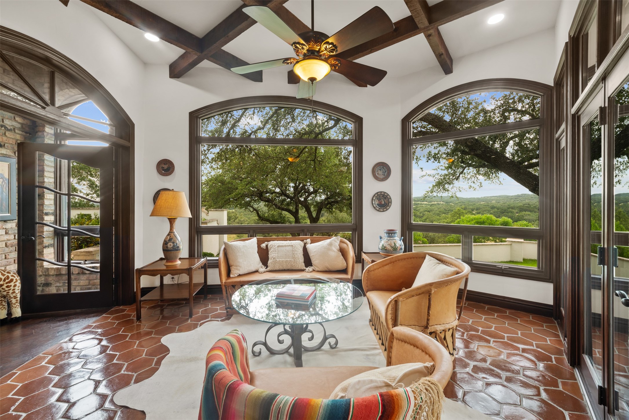 34000 Smithson Valley Road Bulverde, TX 78163 - Photo 11 of 50 This light-filled sunroom offers panoramic views through oversized arched windows, creating a peaceful space to relax and take in the surrounding natural beauty. Architectural details and abundant natural light make this room truly special.