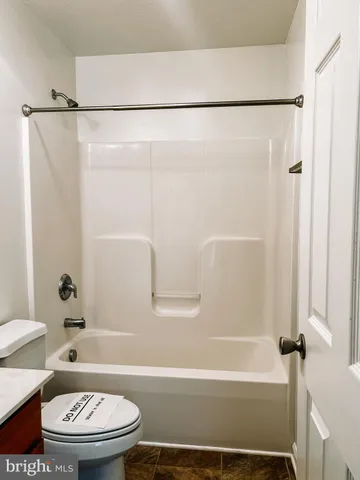 a bathroom with a toilet and a bath tub